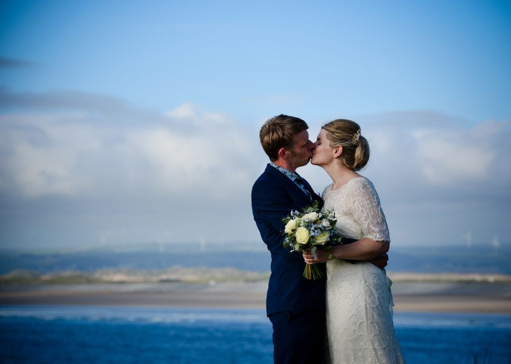 a man and woman kissing on the beach