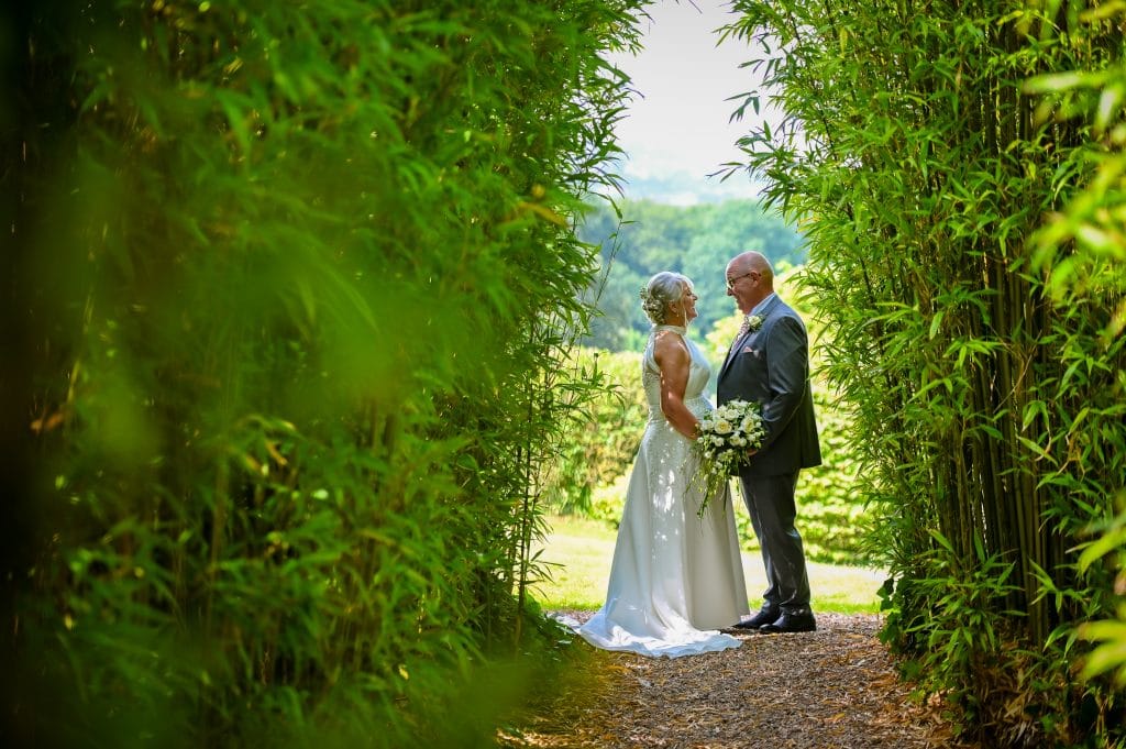 a man and woman standing in a garden