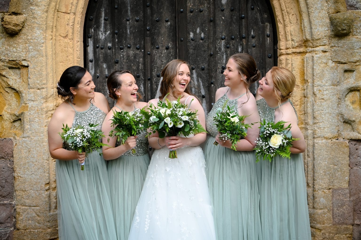 a group of women in dresses holding flowers
