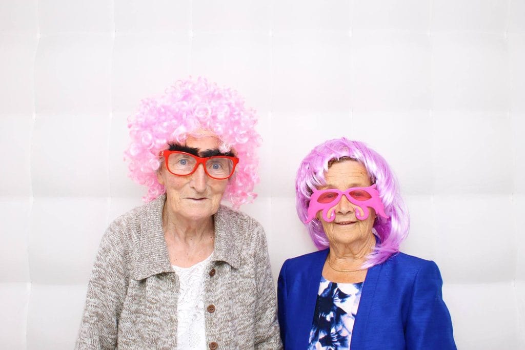 two women wearing pink wigs and glasses