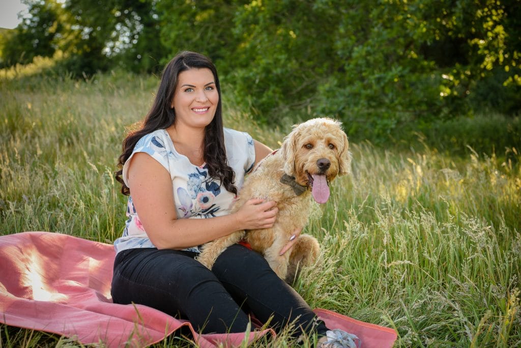a woman sitting on a blanket with a dog