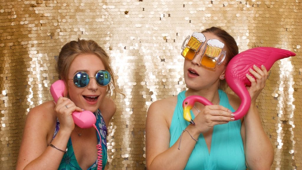 two women holding pink objects