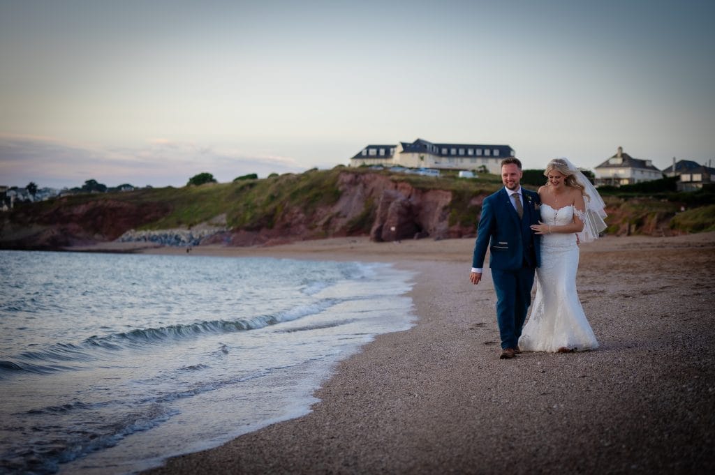 a man and woman in wedding dress on a beach