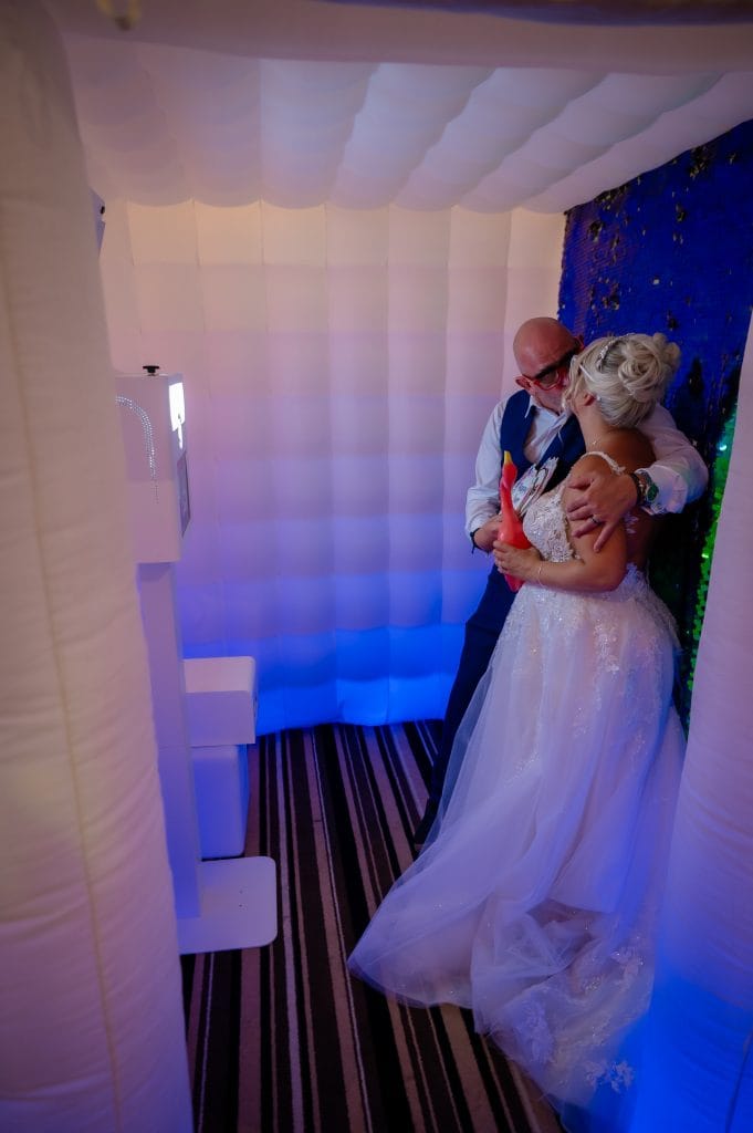 a man kissing a woman in a photo booth
