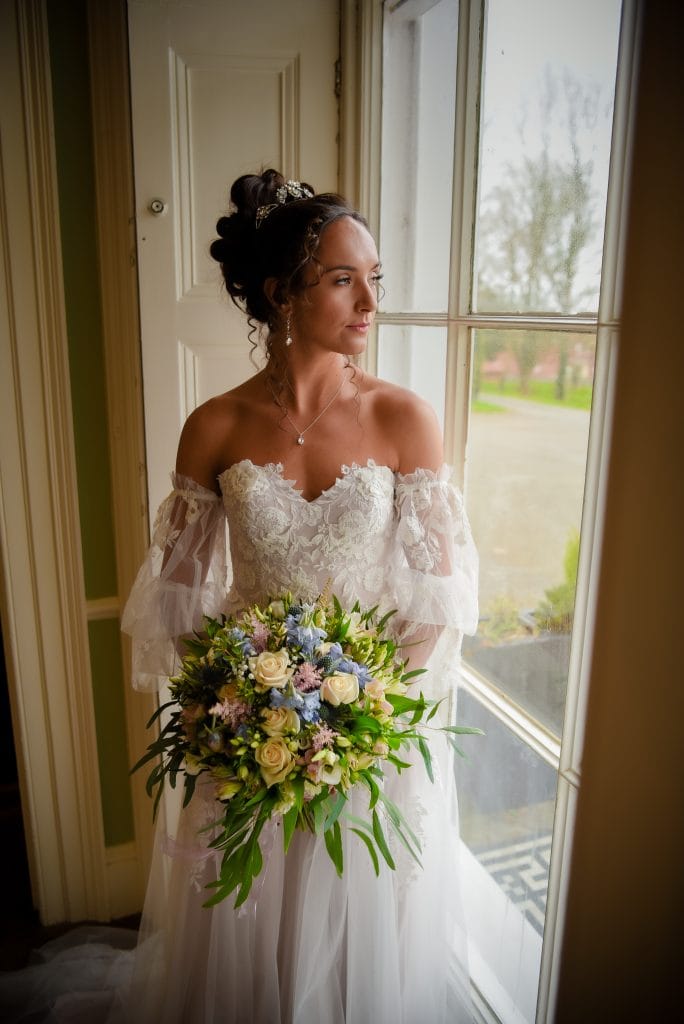 a woman in a white dress holding a bouquet of flowers