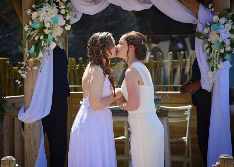 two women kissing under a canopy