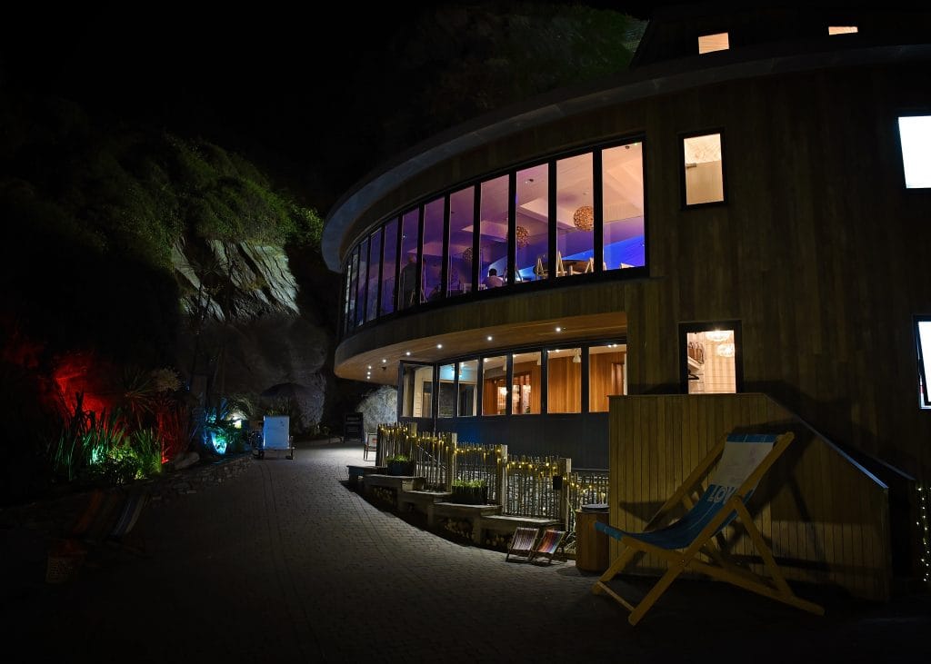 a building with a round window and chairs outside at night