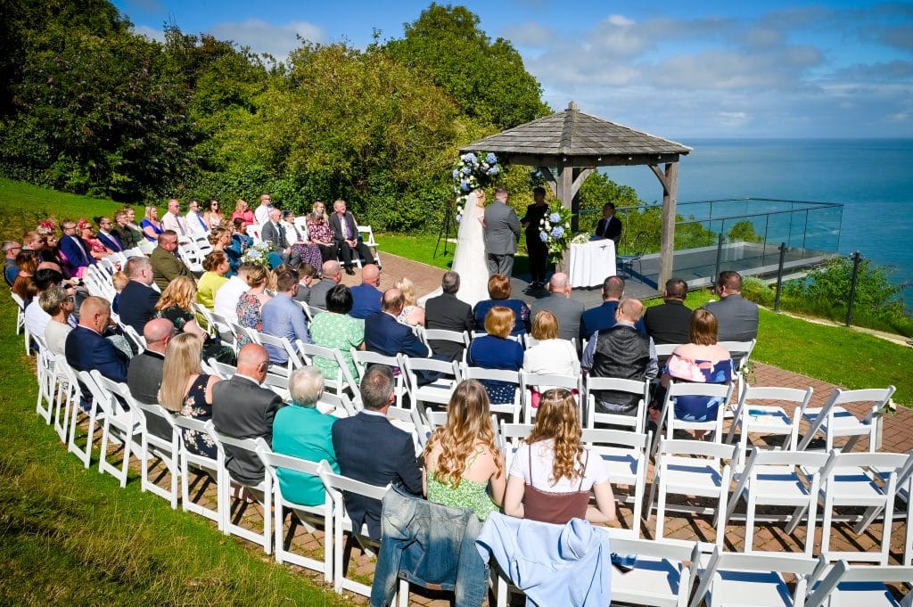 a group of people sitting in chairs at a wedding ceremony